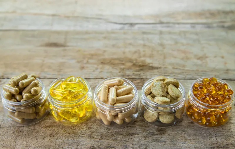 1 supplements-vitamins-medicinal-herbs-glass-jars-wooden-table